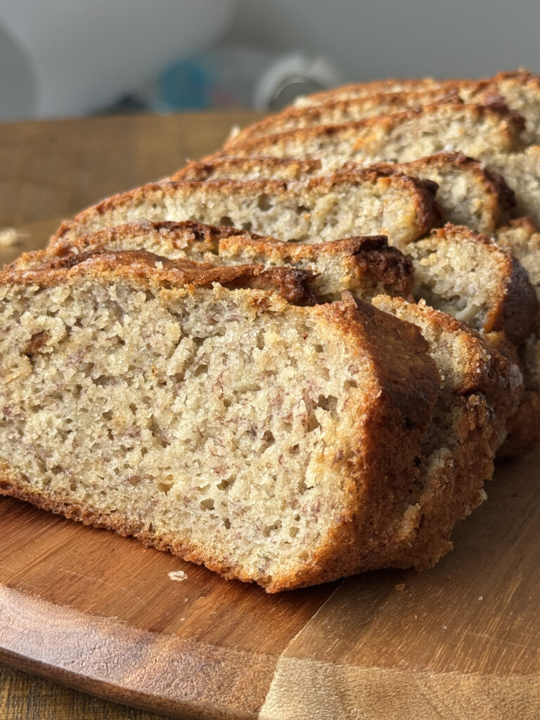 sourdough discard banana bread sliced on a wooden cutting board