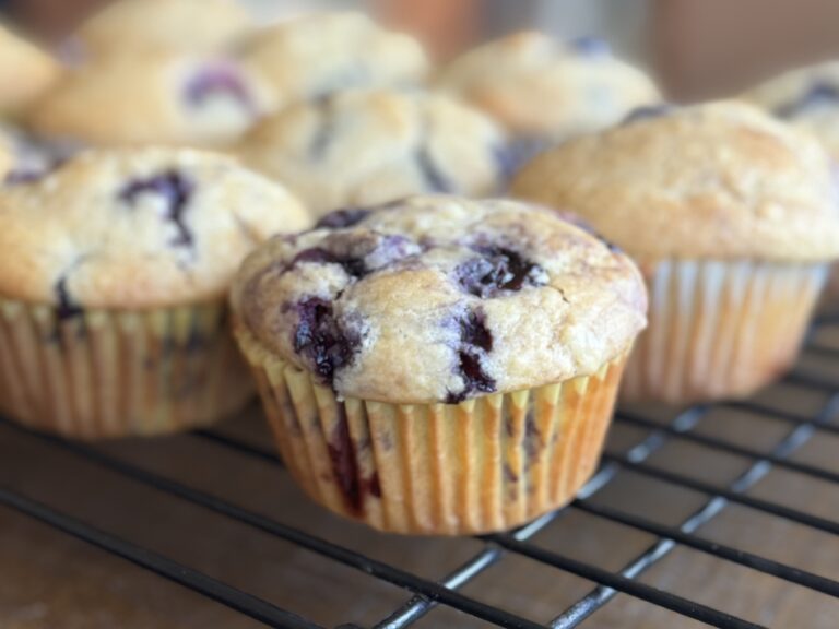 side view of sourdough blueberry muffins with muffin paper on.