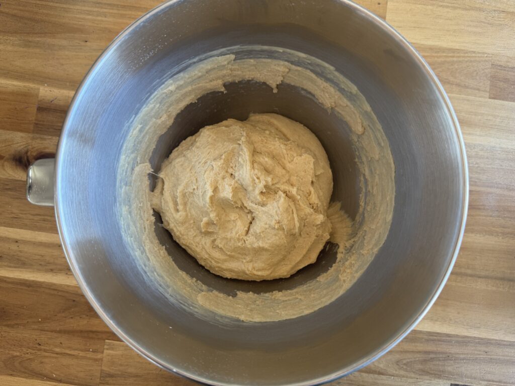 a mixing bowl with hamburger bun dough ready to rise.