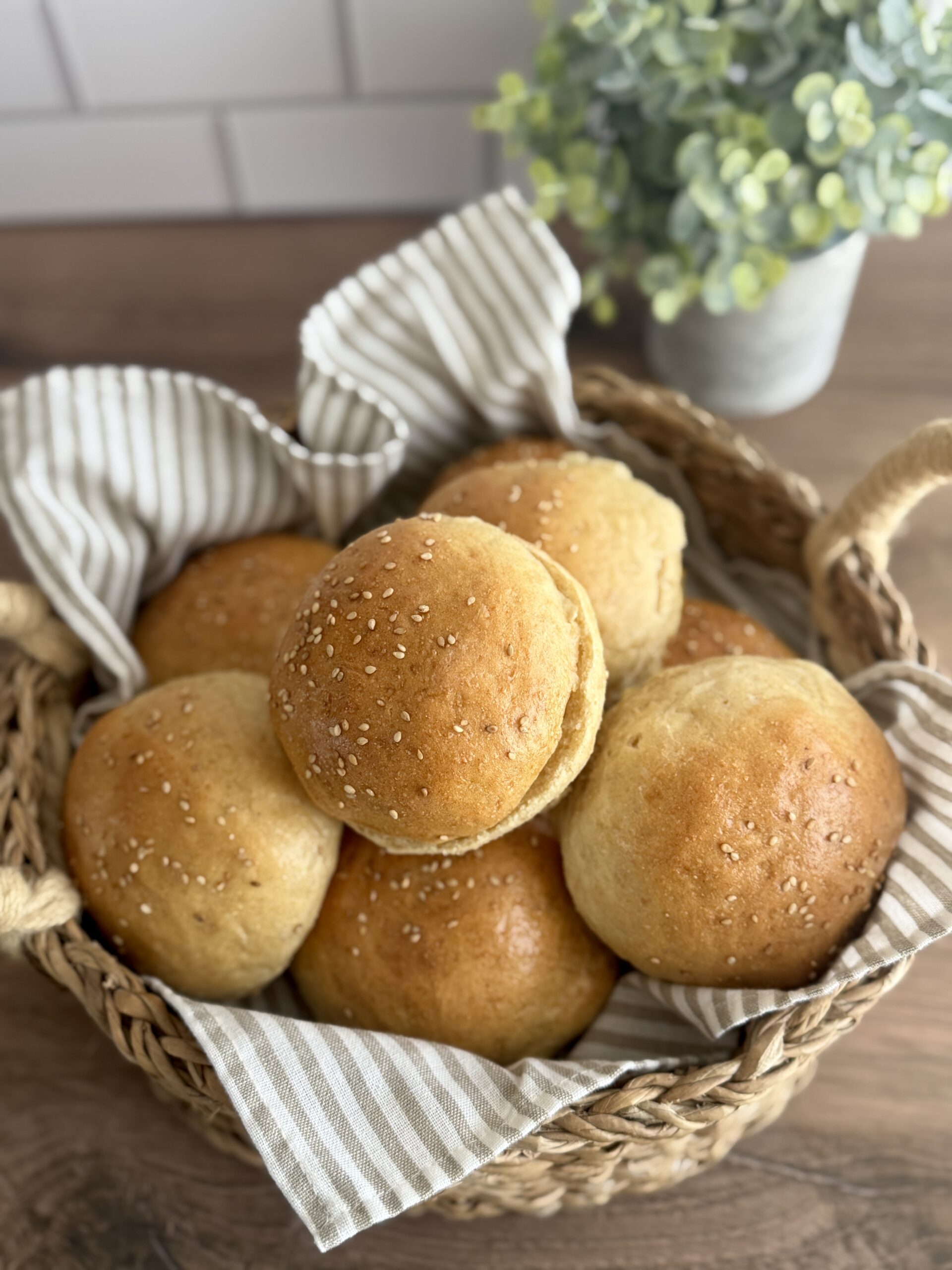 a basket lined with a linen full of sourdough hamburger buns